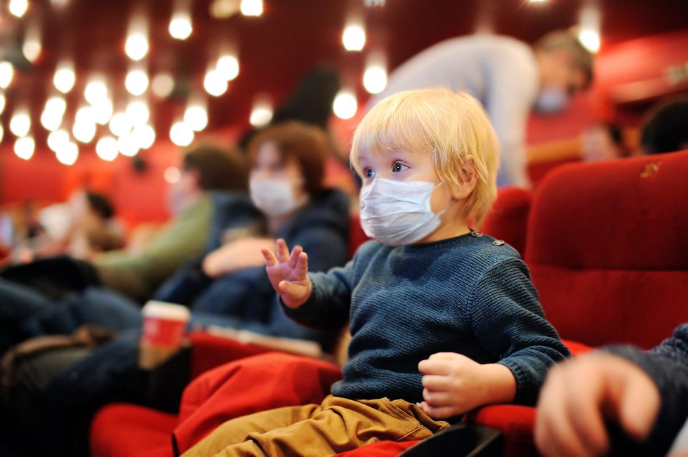 Child in face mask in theater