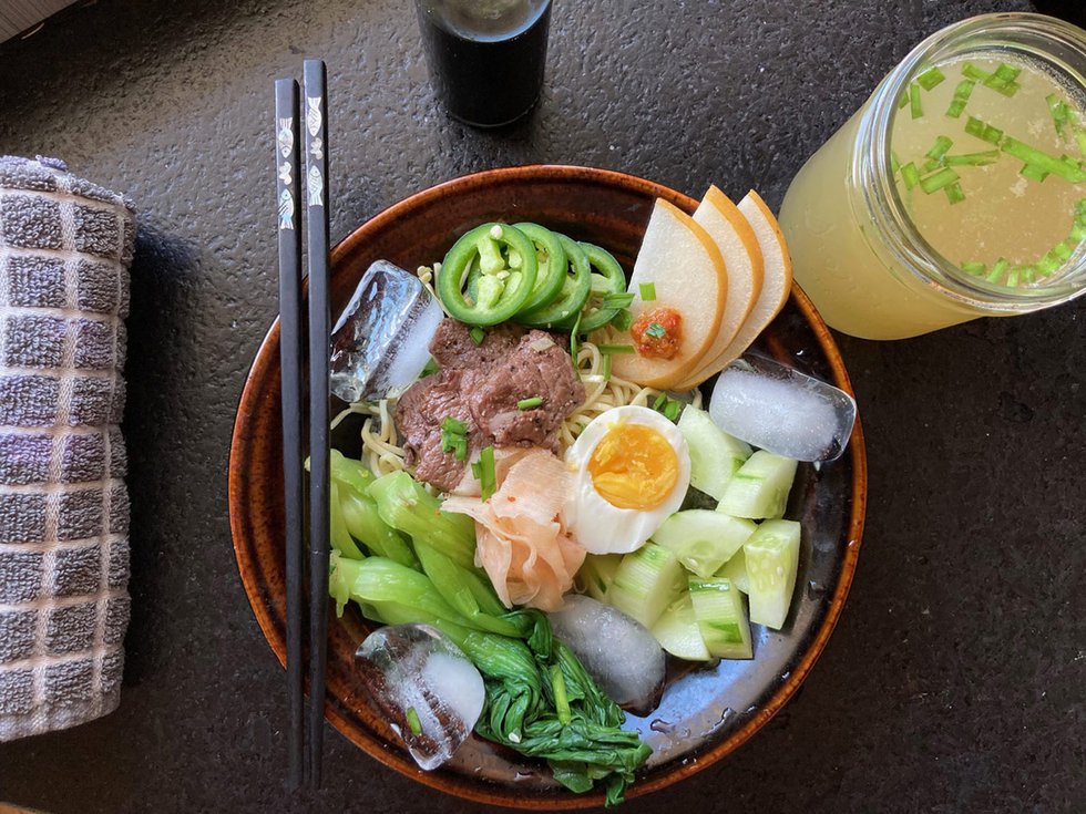 A bowl of naengmyeon, with chilled broth at the ready.