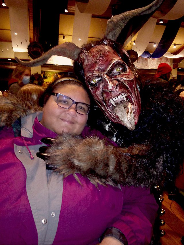 Ashley Denise is hugged and spared by a roaming Krampus at the 2021 Milwaukee Krampusnacht event.
