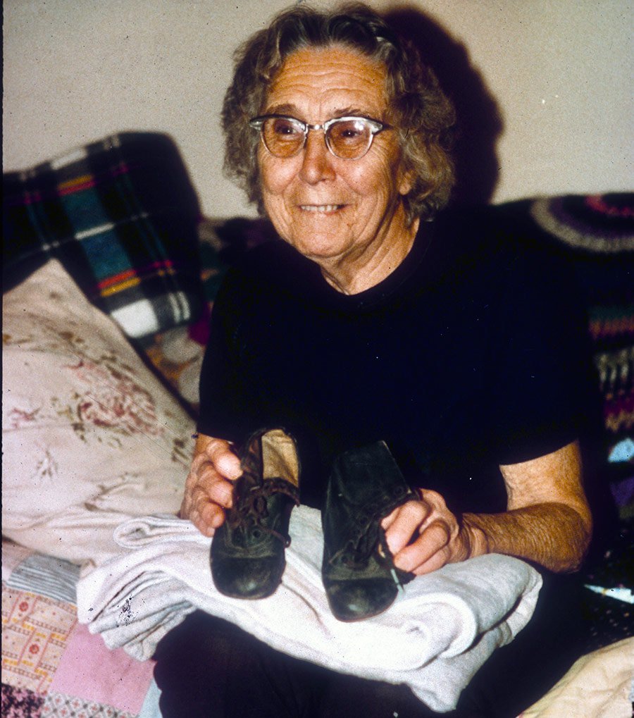 Louise Pope showing her shoes and blanket from the Titanic disaster